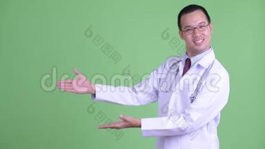 快乐的亚洲男子医生展示了一些东西